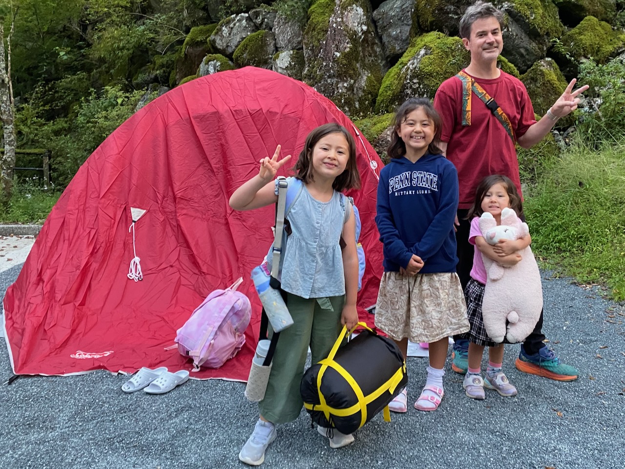 A family standing beside a tent at Yumenomori Campground
