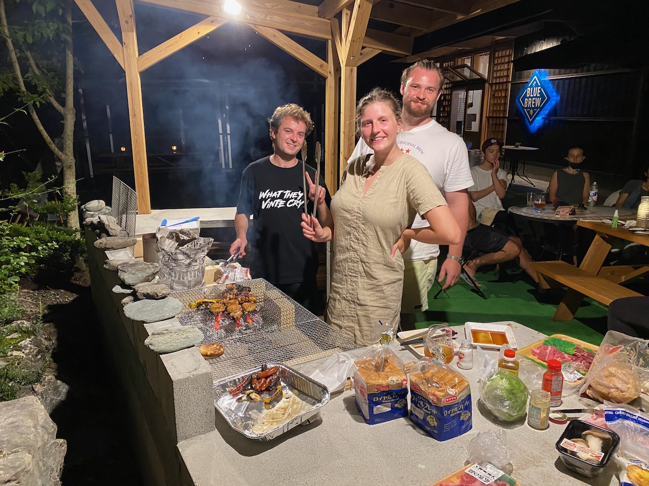 Guests grilling food at the covered Blue Brew BBQ area.