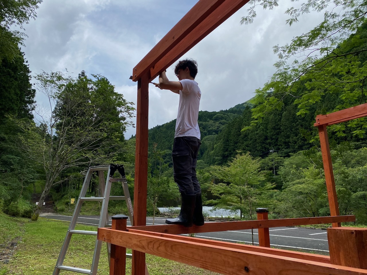 A person working on the wooden frame of the planned first glamping deck at Yumenomori