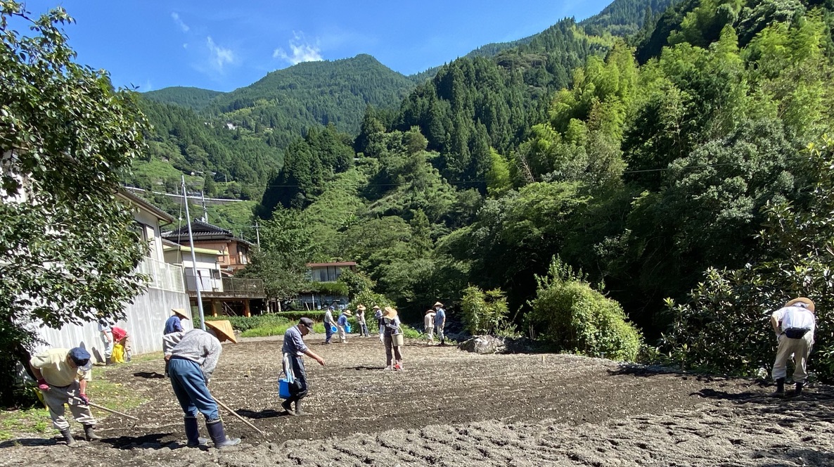 Community members planting soba in a field near Shimonanosato
