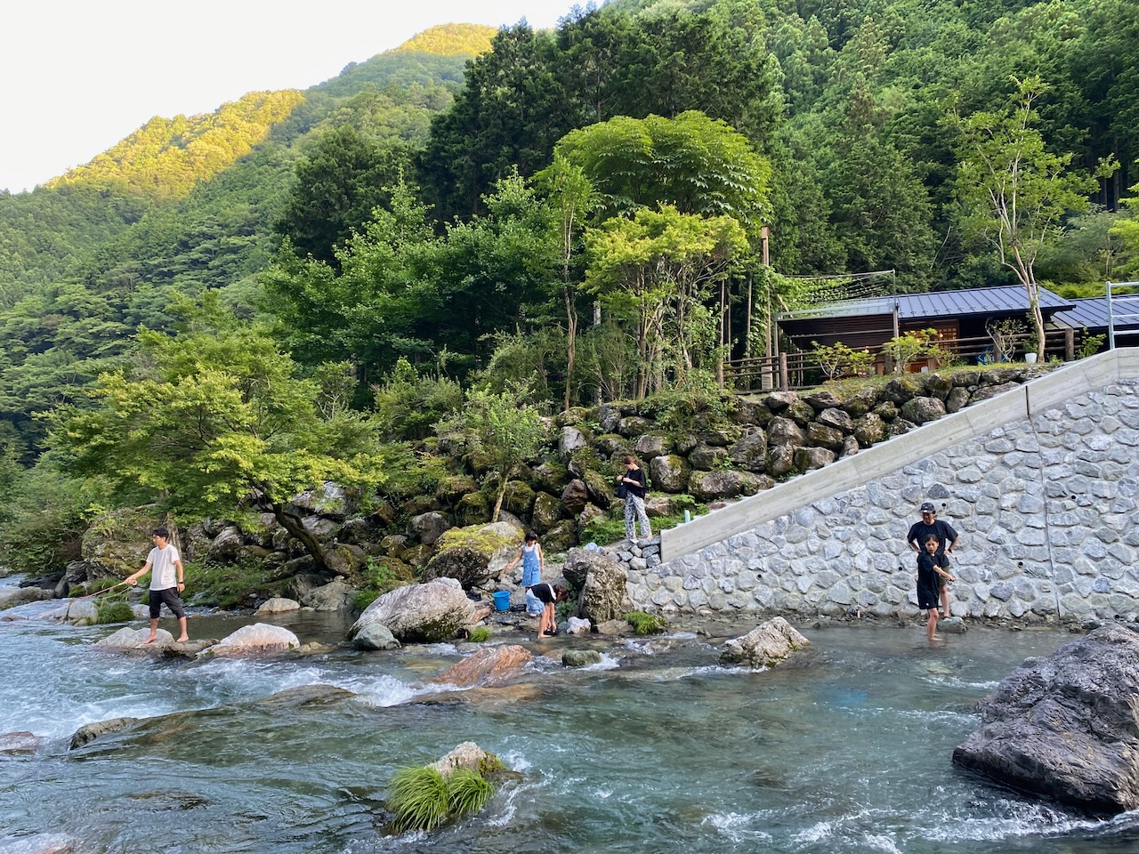 Visitors enjoying the clear waters of the Nakatsu River beside Blue Brew in Niyodogawa, Kochi.