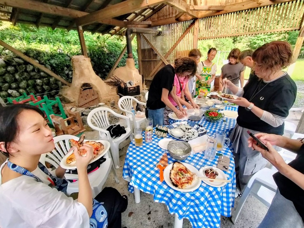 Guests eating pizza and salad together during the wood-fired pizza experience
